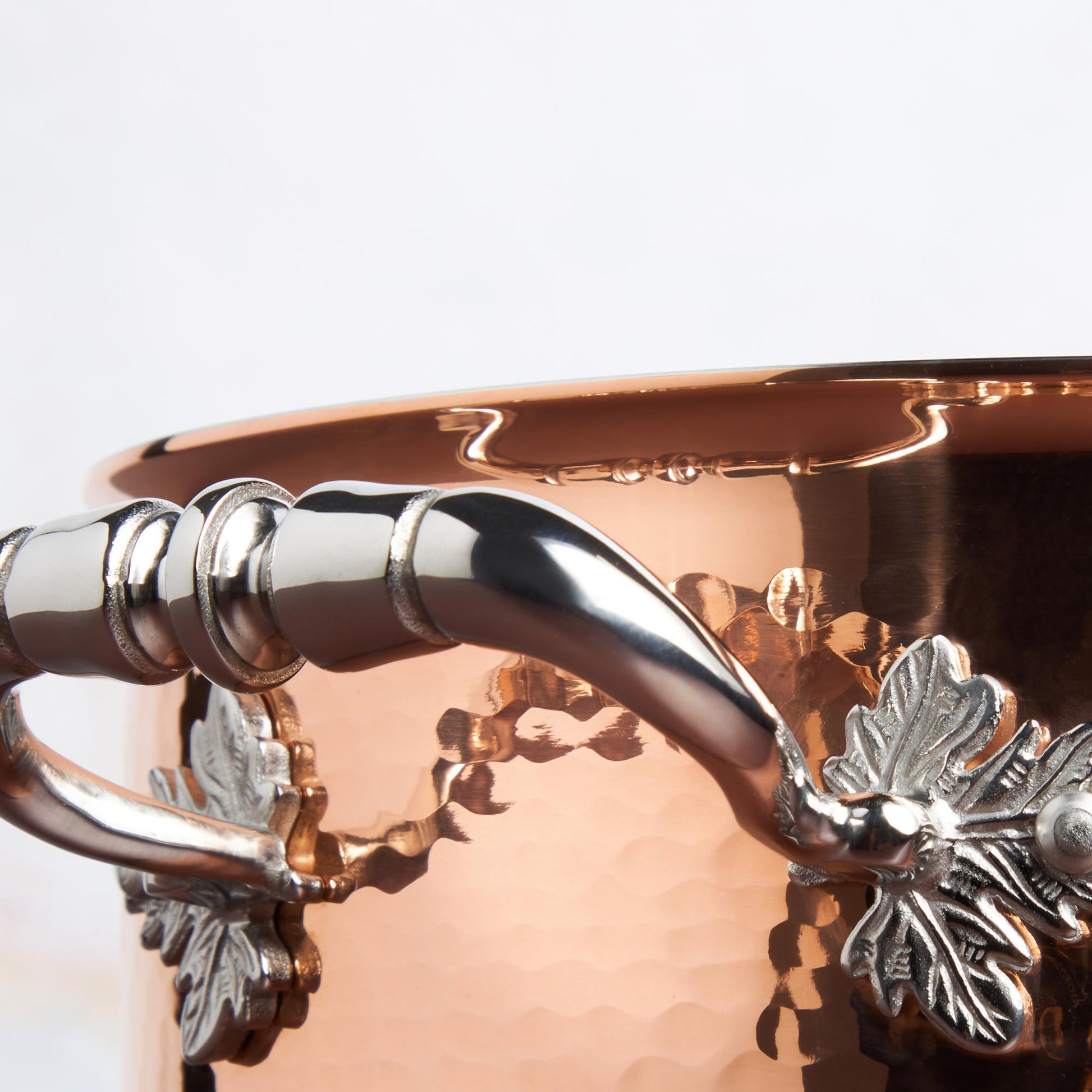 Beautiful stainless steel handle decorated with delicate leaves on Opus Cupra cookware by Ruffoni