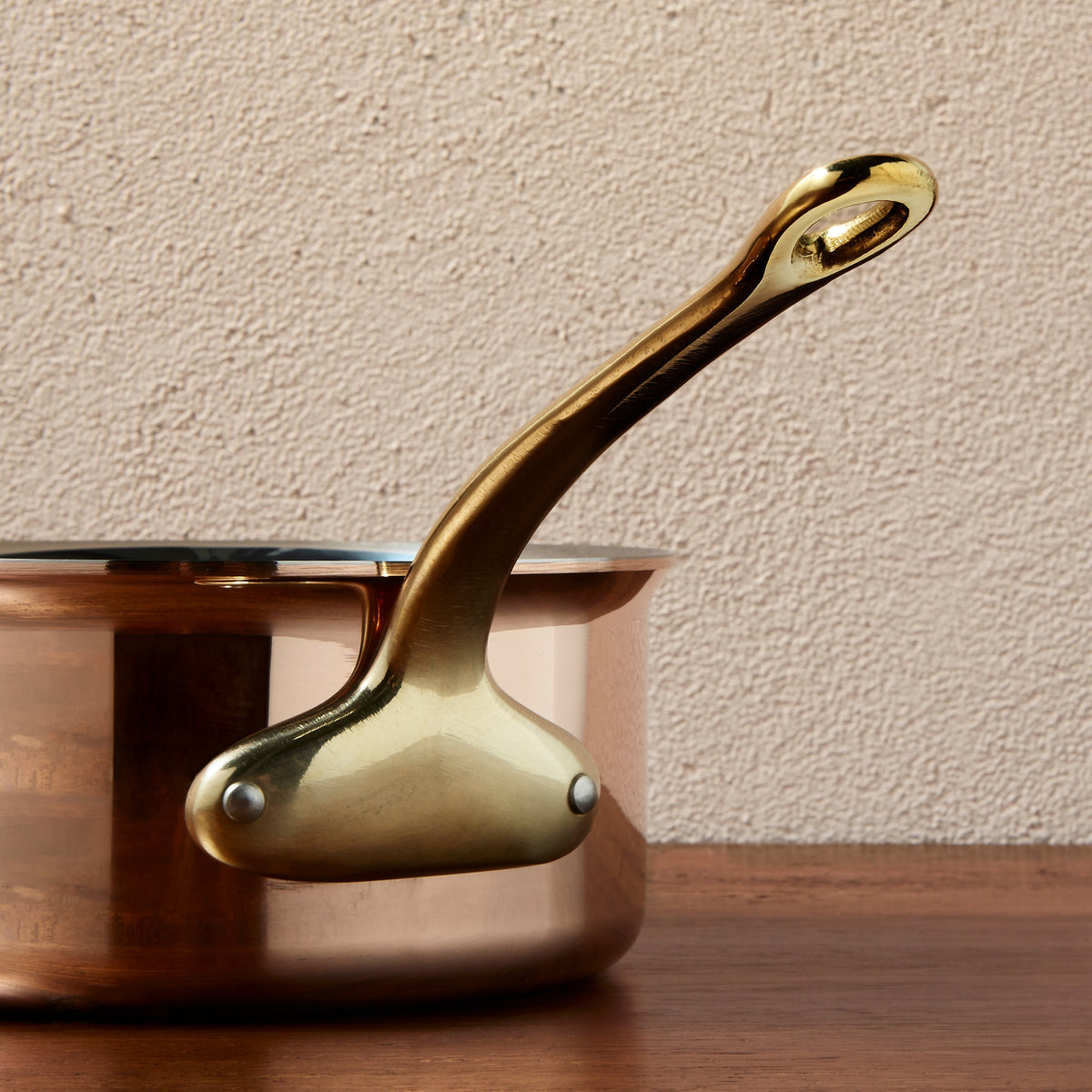 Side view of the  brass handle on a Ruffoni Olivia Cupra copper saucepan