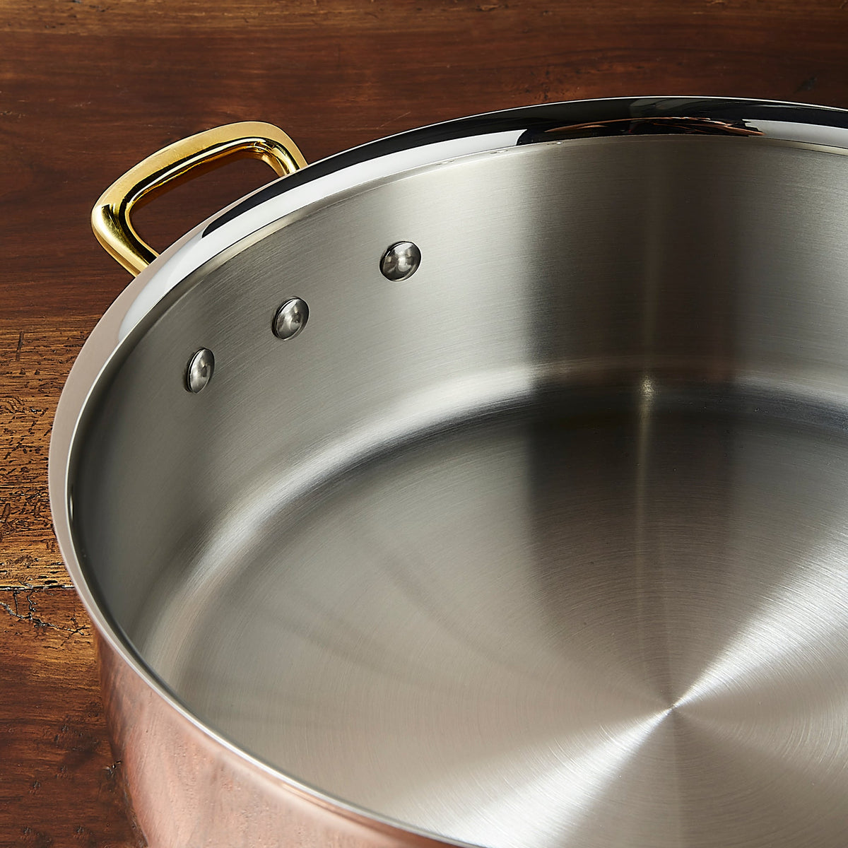 Stainless steel lined interior of a Ruffoni Olivia Cupra copper braiser with brass side handles