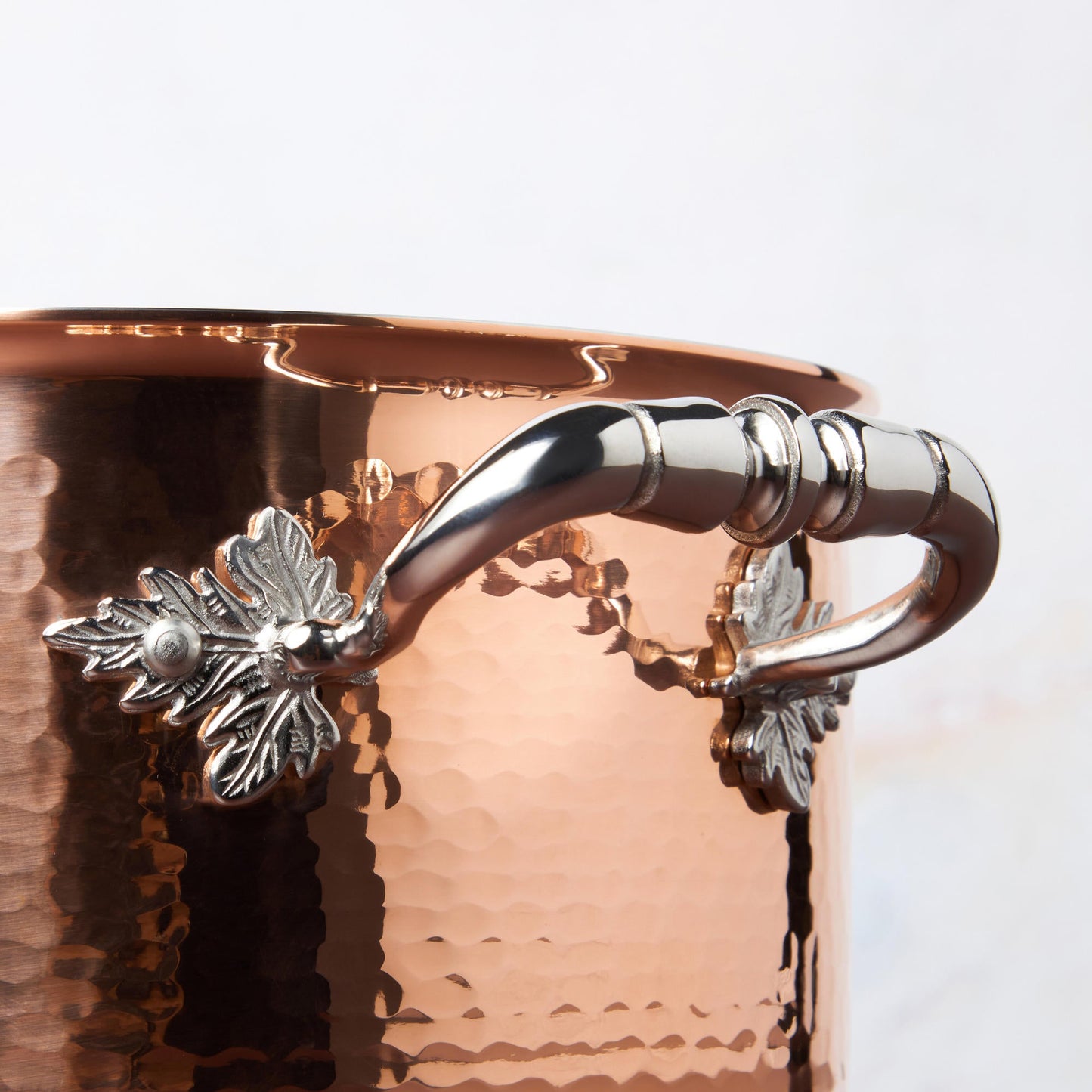 Beautiful stainless steel handle decorated with delicate leaves on Opus Cupra cookware by Ruffoni