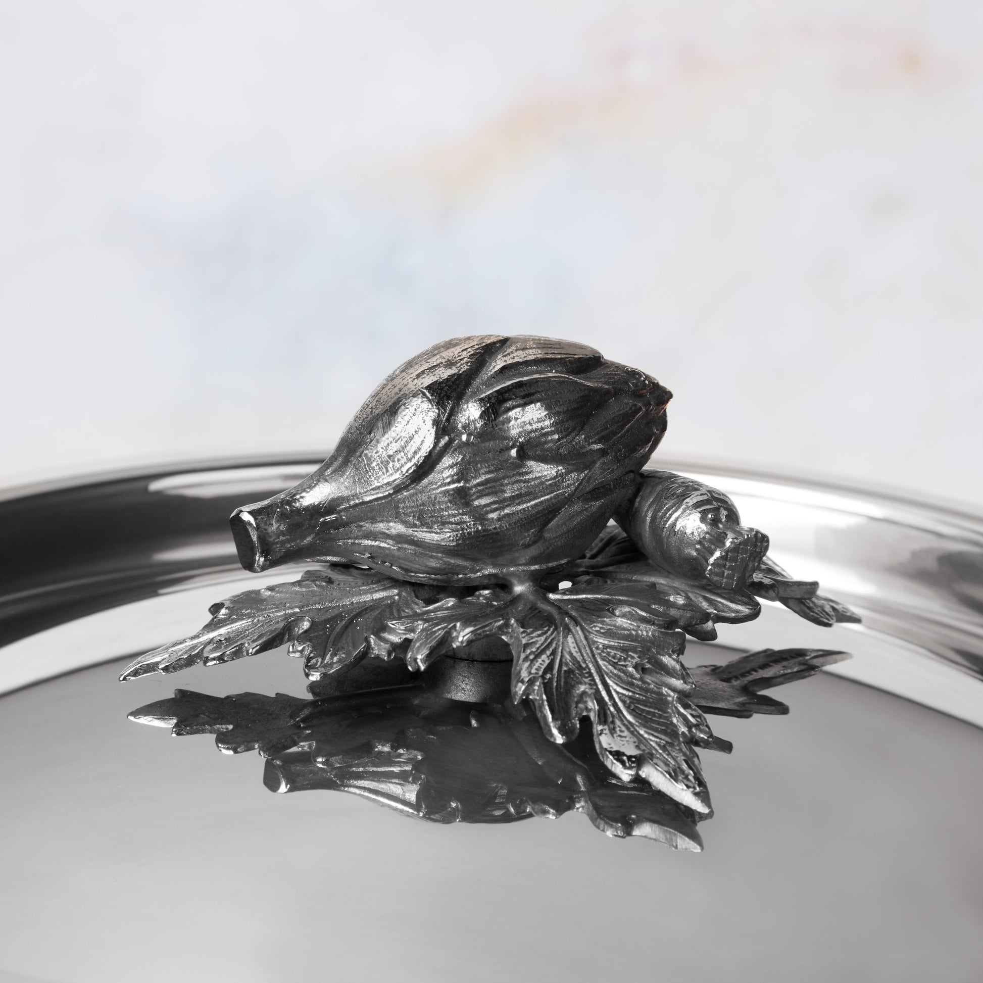 Decorated knob finial representing  artichoke  and carrot, cast in solid bronze and silver plated, on Opus Prima stainless steel lid by Ruffoni