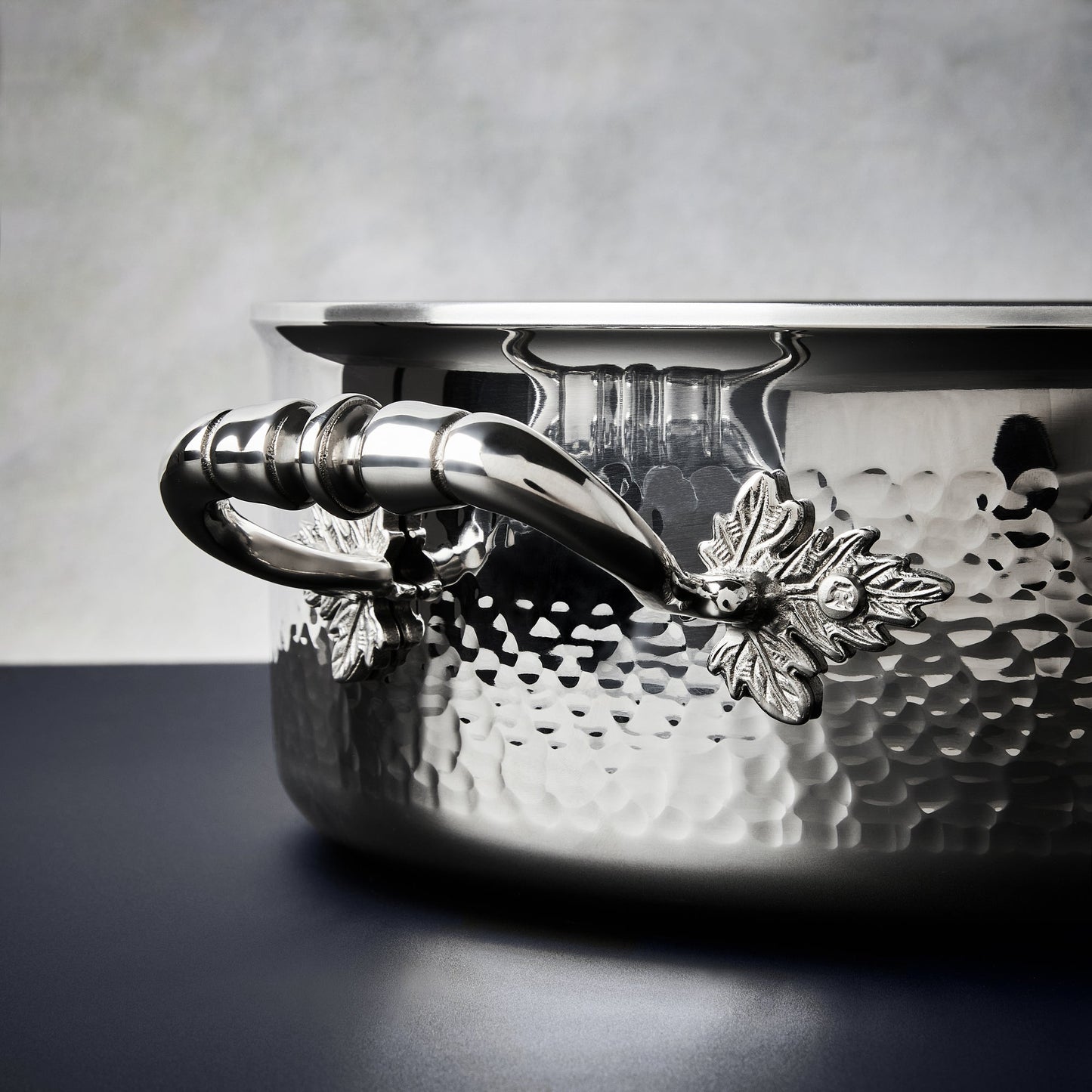 Beautiful clad stainless steel handle decorated with delicate leaves on Opus Prima cookware by Ruffoni